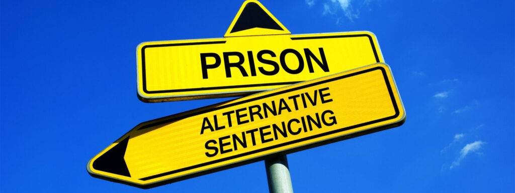 Two signs with the words prison and alternative sentencing 