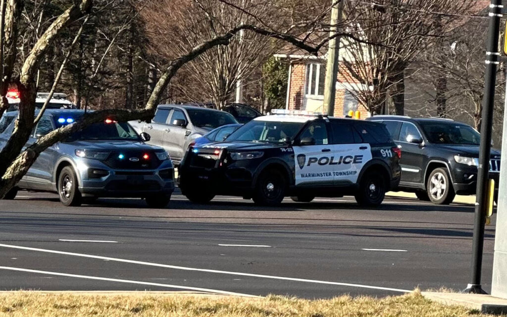 Police conducting a vehicle search in a parking lot