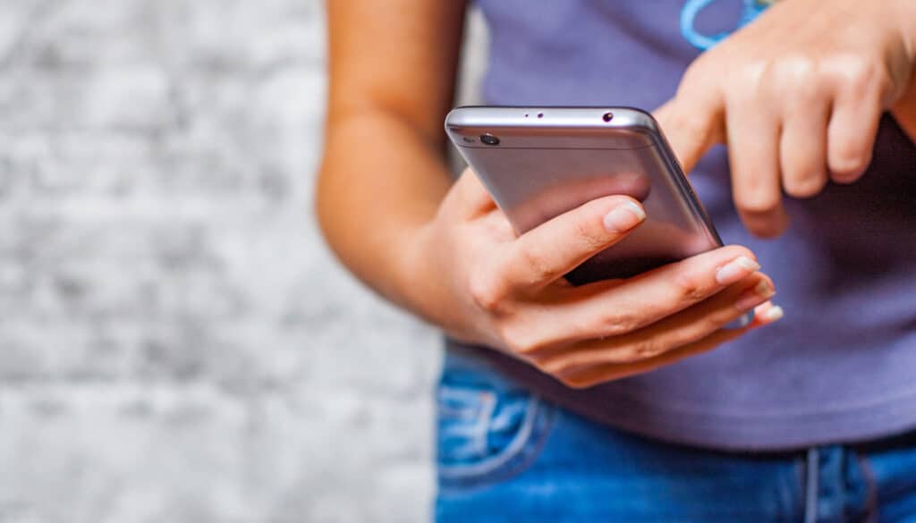 Teenager engaged in sexting with a smartphone