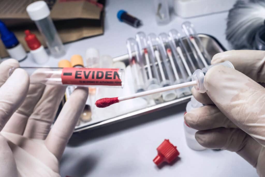 A laboratory technician examines blood and DNA evidence in a sexual assault investigation