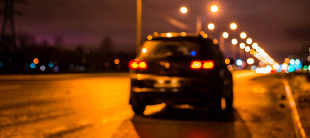 Vehicle parked on the shoulder of the road at night