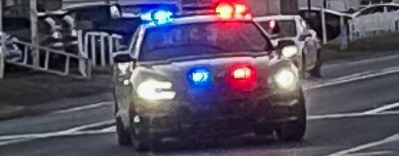 Police car with overhead lights on during a DUI car stop.
